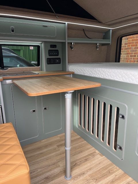 fixed campervan bed with a dog crate underneath. travelling with a dog from the UK to Europe